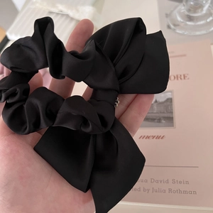 Elegant black satin bow hair scrunchie with large ribbon design and elastic tie