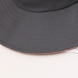 Detail of dark grey sun hat brim with orange lining and reinforced stitching lines