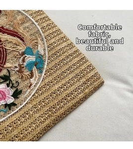 Detailed close-up of Chinese phoenix and peony embroidery on woven straw tote bag surface