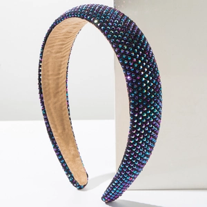 Close-up of rainbow rhinestones and soft brown velvet lining on a sponge headband