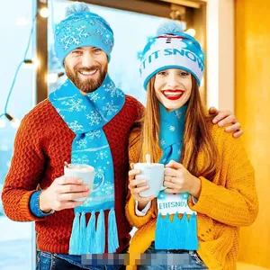 Close-up of blue knitted Christmas hat and scarf set with Let It Snow snowman patterns