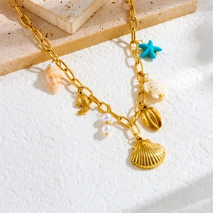 Gold stainless steel ocean necklace with blue starfish, sea turtle, and pearl charms