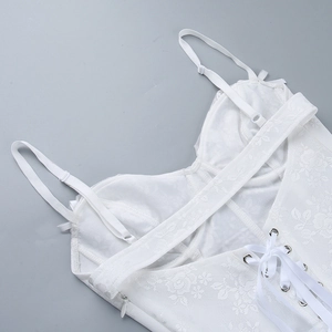 Détails de la robe en dentelle blanche montrant les bretelles et le laçage au dos