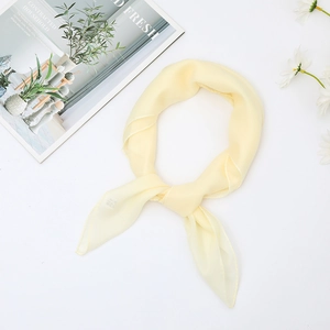 Detail of yellow silk scarf with 100% silk label and elegant sheer texture