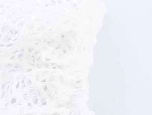 Detailed macro view of breathable white floral lace fabric with soft mesh texture