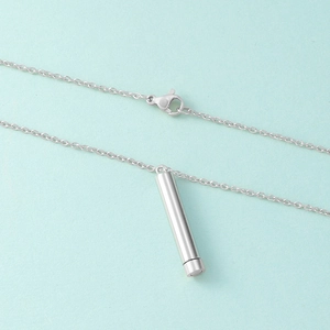 Detailed view of silver stainless steel cylindrical pendant with lobster clasp and chain