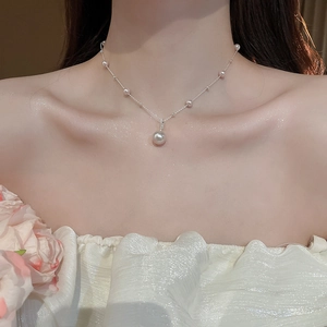 Detail of elegant irregular pearl pendant necklace on model collarbone with silver chain