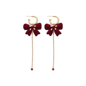 Elegant red velvet bow earrings with golden tassels and zircon accents on white background