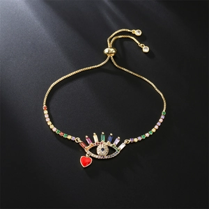 Detail of evil eye bracelet with colorful zircons and red enamel heart charm