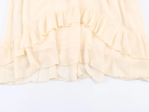 Vista dettagliata dei volant in chiffon beige sull'orlo di un abito midi elegante