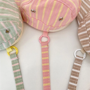 Detail of colorful striped canvas crossbody bags with metal eyelets and matching lanyards