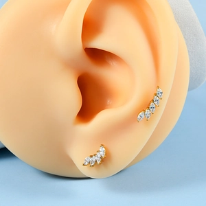 Gros plan de clous d'oreilles courbés en zircon marquise sur un modèle en silicone
