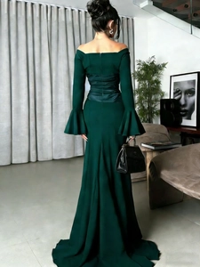 Detail of slim fit dark green off-shoulder evening dress with elegant back ruching
