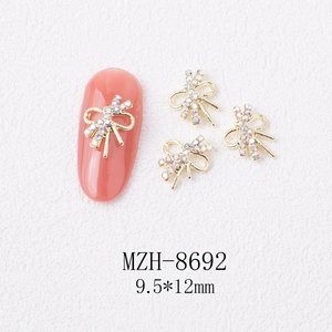 Detail of 3D gold alloy bow nail charms with rainbow rhinestones, size 9.5x12mm