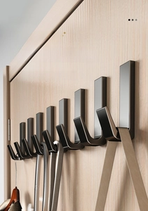 Detail of solid thickened alloy wall hooks in matte grey finish on wooden board
