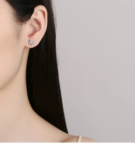 Close-up of model wearing silver butterfly stud earrings with sparkling cubic zirconia
