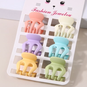 Close-up of 6 colorful matte mini hair claw clips in macaron tones on a display card