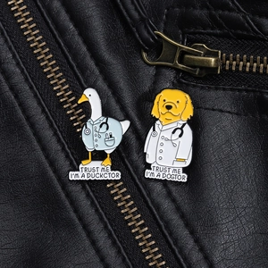 Funny enamel pins featuring a doctor duck and dog on a textured black leather jacket