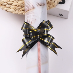 Detail of a black gift bow with double gold stripes for elegant gift wrapping