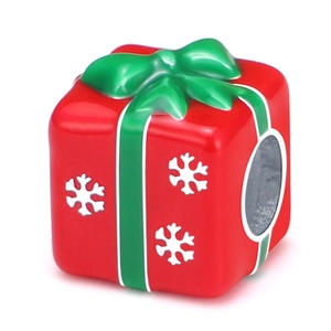 Macro shot of red Christmas gift box charm with green bow and white snowflake patterns