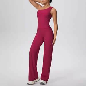 Détail du haut de yoga asymétrique et du pantalon large en tissu extensible rouge foncé mat