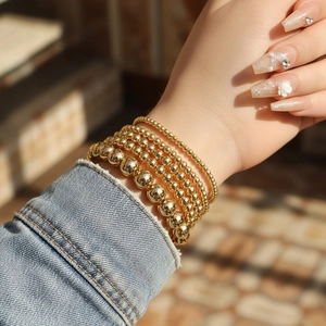 Detail of 5-piece 18K gold plated bead bracelet set with varying 3mm to 8mm bead sizes