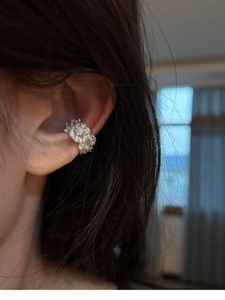 Close-up of silver zircon flower ear cuff worn on ear with sparkling crystal details