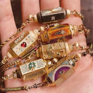 Detailed close-up of vintage gold bracelets with colorful enamel charms and gemstones