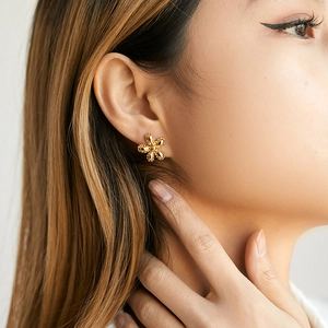 Detail of 18K gold irregular flower stud earring with vintage beaded texture on ear