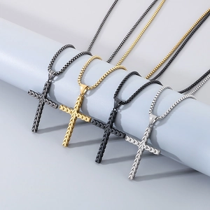Détail de quatre colliers croix texturés en acier inoxydable gris, or, noir et argenté