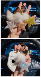 Detailed view of rhinestone star keychains with faux mink fur pom-poms in three colors