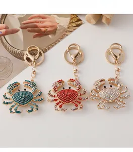 Detailed macro view of three crystal-encrusted metal crab keychains in various colors