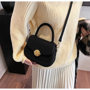 Model view of black saddle crossbody bag with golden metal lock and matte leather finish
