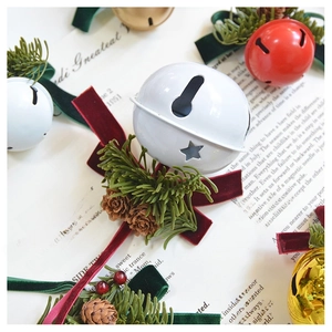 Detail of metal Christmas bells with velvet bows, pine needles and natural cones