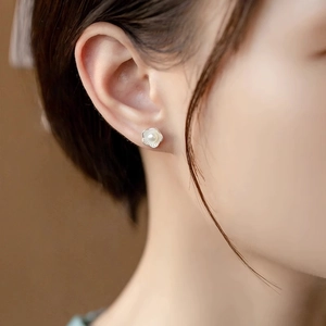Elegant silver double-layer lotus pearl earrings worn by a model in a side profile view