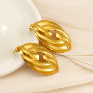 Macro shot of 18K gold plated stainless steel textured oval earrings on ceramic plate