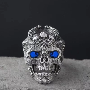 Vue détaillée d'une bague crâne avec yeux en pierres bleues et gravures punk