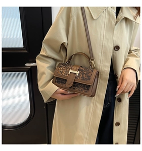 Detail of retro leopard print handbag with golden square buckle on khaki trench coat