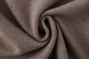 Detailed macro texture of dark brown knit fabric showing soft cotton wool blend fibers