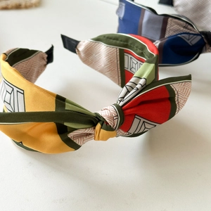 Elegant satin knot headband featuring a colorful geometric patchwork pattern on white background