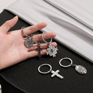 Detail of silver religious charms including cross and Saint Christopher medal on keyrings
