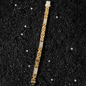 Macro view of gold chain bracelet with cubic zirconia tiles and classic cuban links