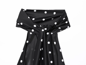 Detail of a black and white polka dot sleeveless top showing silky satin fabric texture