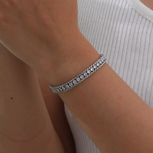 Detail of a gold curb chain bracelet with sparkling black zircon stones on a model wrist