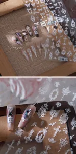 Détail d'autocollants 3D pour ongles avec nœuds et dentelle blanche aux motifs gothiques