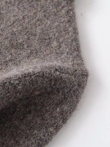 Nahaufnahme der taupefarbenen Plüsch-Stricktextur mit weichen Wollfasern und feinen Details