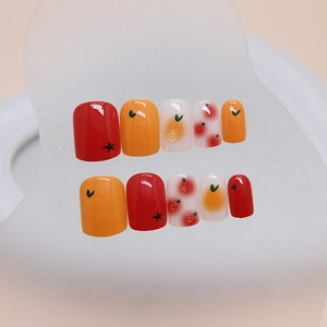 Short press-on nails with fruit patterns including orange and strawberry hand-painted designs