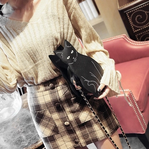Cute black cat shaped crossbody bag with gold chain strap for women shown on shoulder