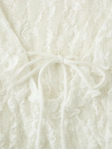 Macro shot of white lace top detailing fine fabric texture and front bow tie design