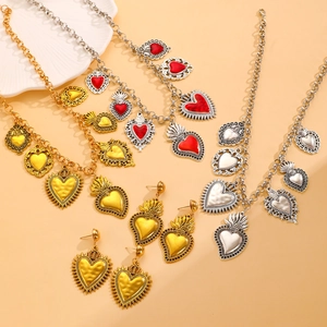 Detailed flat lay of vintage sacred heart pendants in gold and silver finish